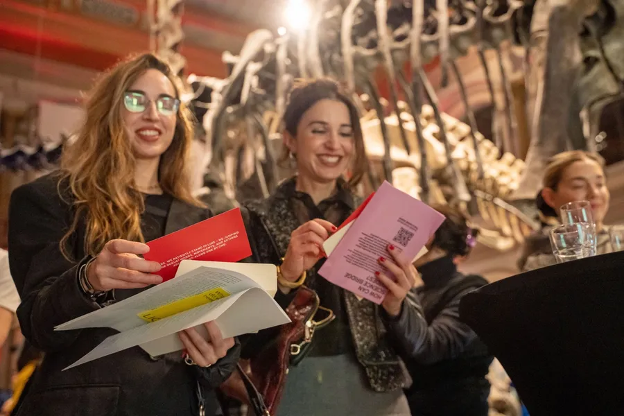 Zwei Teilnehmerinnen lesen lachend ihre Workshop-Karten in einem Museum